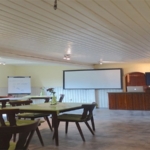 Seminarraum des Hundezentrum Pfalz mit Tischen, Stühlen, Leinwand und Bildschirm